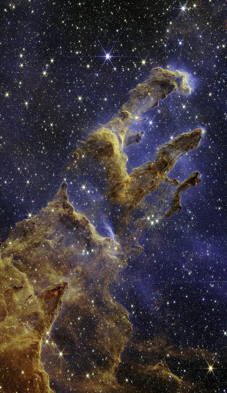 The Pillars of Creation seen in infrared by the James Webb Space Telescope, revealing young stars hidden inside the dusty columns
