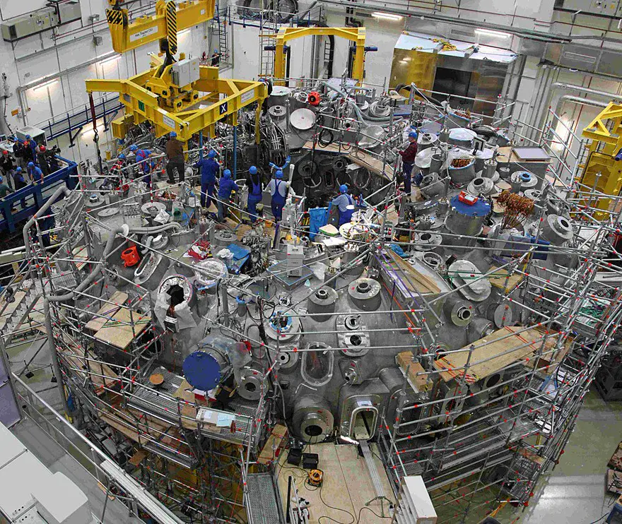 The interior of the Wendelstein 7-X stellarator hall in Greifswald, showing its complex twisted magnetic coils